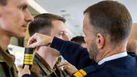 Konteradmiral Ralf Kuchler befördert einen Lehrgangsteilnehmer