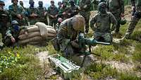 a soldier is kneeling next to other soldiers and explains something to them