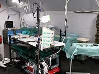 Im Innern eines großen Zeltes befinden sich Liegen, medizinische Geräte und Instrumente. 