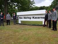 Mehrere Personen stehen links und rechts neben einem Schild mit der Aufschrift „Von-Düring-Kaserne".