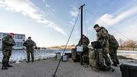 Soldaten bauen eine Antennenanlage auf.