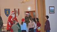 Ein Weihnachtsmann begrüßt die Kinder bei seinem Eintreffen.
