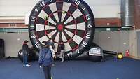 Kinder stehen vor einem großen Fussball-Dart.