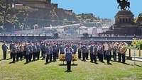 Das Heeresmusikkorps Koblenz in voller Aufstellung vor historischer Kulisse