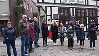 Eine Menschgruppe steht bei einer Stadtführung auf dem Schlachtermarkt in Schwerin.