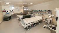 Ein medizinischer Raum mit medizinischer Geräten und zwei Rettungsliegen.