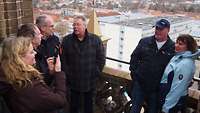 Mehrere Menschen schauen auf Neubrandenburg vom Dach der Konzertkirche.