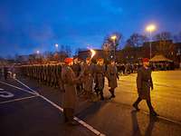 Mehrere Soldaten marschieren in Dunkelheit auf einem Paradeplatz im Rahmen eines Feierlichen Gelöbnis