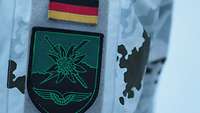 Patch am Arm eines Soldaten in hellem Schneetarnanzug