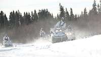 Kommandosoldaten mit Skidoo-Schneemobilen beim Fahrtrainung auf einem zugefrorenen Gewässer