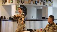 Eine Soldatin erklärt und legt exemplarisch am Arm ein Tourniquet eine Art Gurt zum Stillen bei starken Blutungen an.