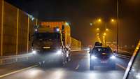 Ein Lkw mit großem Seecontainer fährt bei Nacht auf einer polnischen Autobahn