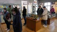 Menschen betrachten die Ausstellungsstücke aus 40 Jahre DDR Konsumgeschichte.