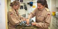 Zwei Soldatinnen prüfen die Medikamente, die sich in Rettungsrucksäcken befinden