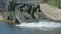Ein Motorboot mit zwei Soldaten darin wird von einer Ladefläche eines Fahrzeuges zu Wasser gelassen