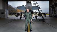 The pilot of a combat aircraft is standing under a Eurofighter.