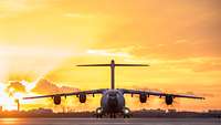 Frontal view of an A400M transport aircraft at sunset at Berlin-Tegel airport.
