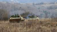 Zwei tschechische Schützenpanzer fahren im Gelände