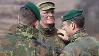 Ein Soldat wird im Gelände vom Hauptmann zum Major befördert