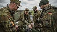 Vier Soldaten bereiten eine Fernbedienbare Leichte Waffenstation von einem GTK Boxer vor