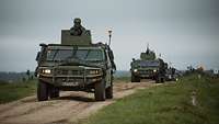 Mehrere Gefechtsfahrzeuge spanischer Streitkräfte befahren einen Truppenübungsplatz