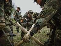 Mehrere Soldaten bauen einen spanischen Reiter