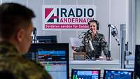 Eine Soldatin steht in einem Aufnahmestudio von Radio Andernach und spricht in ein Mikrofon 