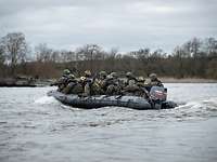 Ein Schlauchboot mit mehreren Soldaten fährt mitten auf einem Gewässer