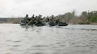 Soldaten fahren in einem Schlauchboot auf einem Gewässer