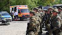 Angetretene Soldaten, im Hintergrund Kräfte und Fahrzeuge von Polizei und Rettungsdienst
