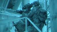 Zwei Kommandokräfte mit Nachtsichtgerät und vorgehaltenem Sturmgewehr gehen in einem Gebäude vor
