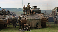 Panzergrenadiere bereiten ihren Schützenpanzer vor, der neben anderen Schützenpanzern steht