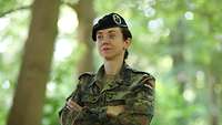 Frau Oberstleutnant Tina B. steht mit verschränkten Armen im Wald