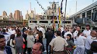 Numerous people are standing on the deck of a ship.