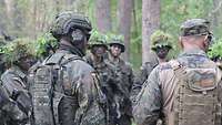 Soldaten stehen im Wald zusammen und besprechen sich