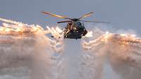 Ein Hubschrauber schießt Täuschkörper im Flug