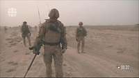 Mehrere Soldaten in einer Wüste, einer der Soldaten geht mit einem Minensuchgerät voran