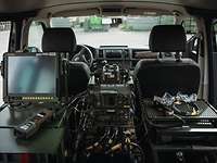 Ein Analogfunkgerät sowie die neue digitale Variante sind übereinander in einem Fahrzeug verbaut.