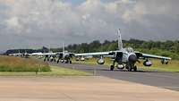 Several fighter jets are taxiing to take off.