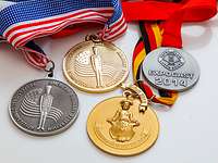 Gold-, Silber- und Bronzemedaillen an Halsbändern auf einem Tisch