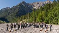 Militärmusiker mit ihren Instrumenten vor einer Bergkulisse