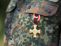 Ein Soldat trägt das Ehrenkreuz der Bundeswehr für Tapferkeit an dem Flecktarn