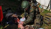 Ein Soldat behandelt zwei verwundete Übungsverletzte