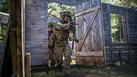 Der Grundriss eines Holzhauses im Wald: Zwei Soldaten im Gefechtsanzug kommen durch die Tür