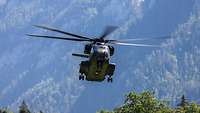 Ein Transporthubschrauber vom Typ CH-53 im Landeanflug in einem Gebirge