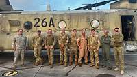 Sieben US-amerikanische und zwei deutsche Soldaten stehen vor einem Hubschrauber