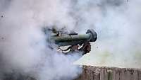 Ein Soldat schießt mit einer Panzerfaust im Anschlag. Viel Rauch liegt in der Luft.