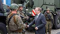 Minister Pistorius begrüßt zwei Soldaten per Handschlag