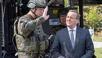 Verteidigungsminister Pistorius steht neben einem Soldaten der ihm etwas erklärt