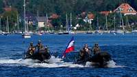 Mehrere Personen sitzen auf einem Speedboot, auch der Bundesminister der Verteidigung